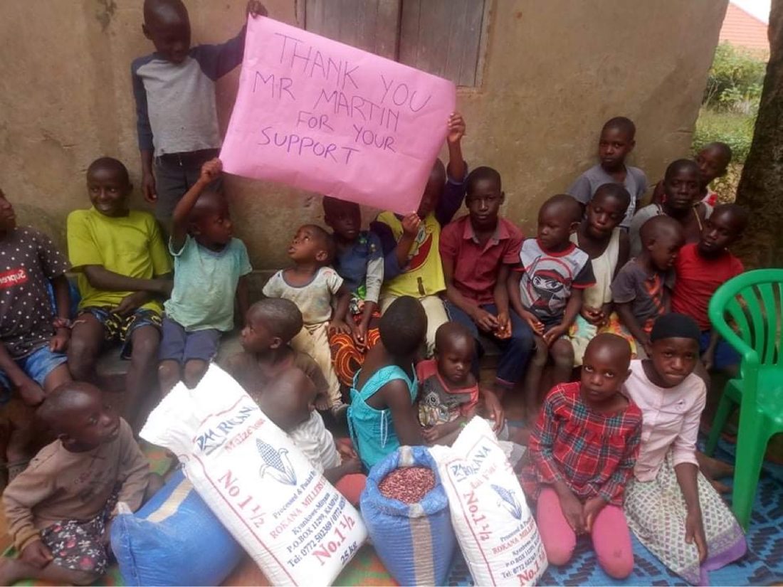 Children at the home with sacks of maize flour and beans delivered as food