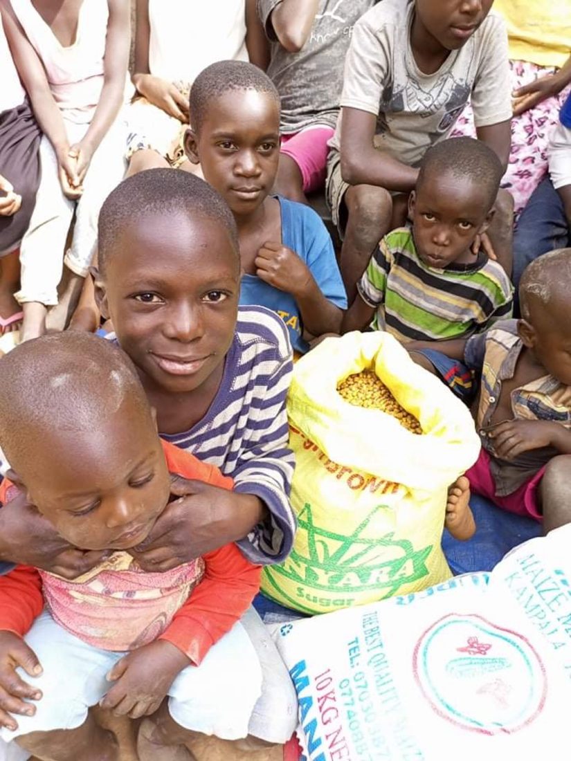 Young children at the home sitting with a sack of food