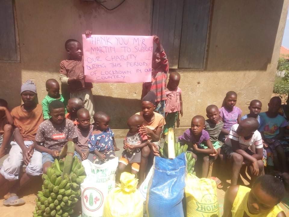 Children at the home with food, holding a thank-you sign during lockdown
